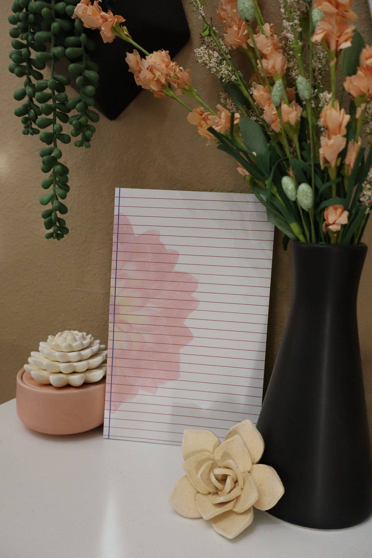 Lined notepad styled with succulents and peach flowers – front view